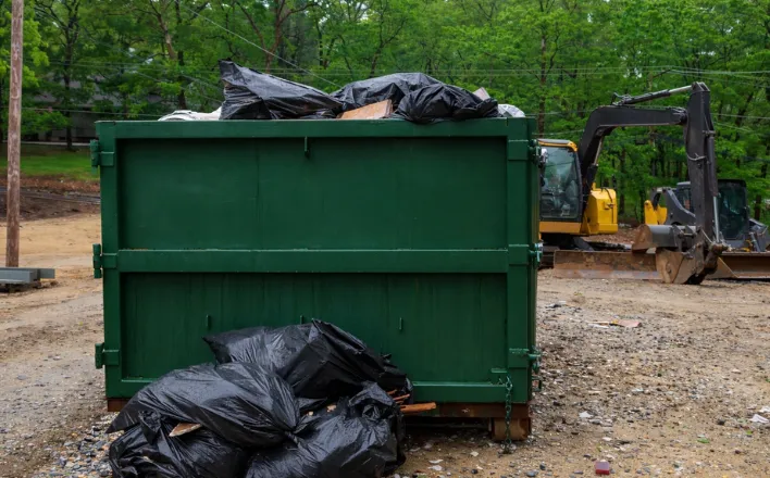 Green roll-off dumpster at a Dallas job site