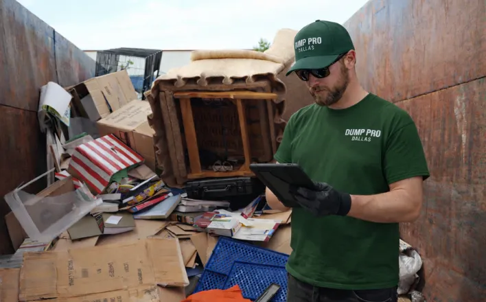 Dump Pro Dallas team inspecting dumpster load for safe hauling