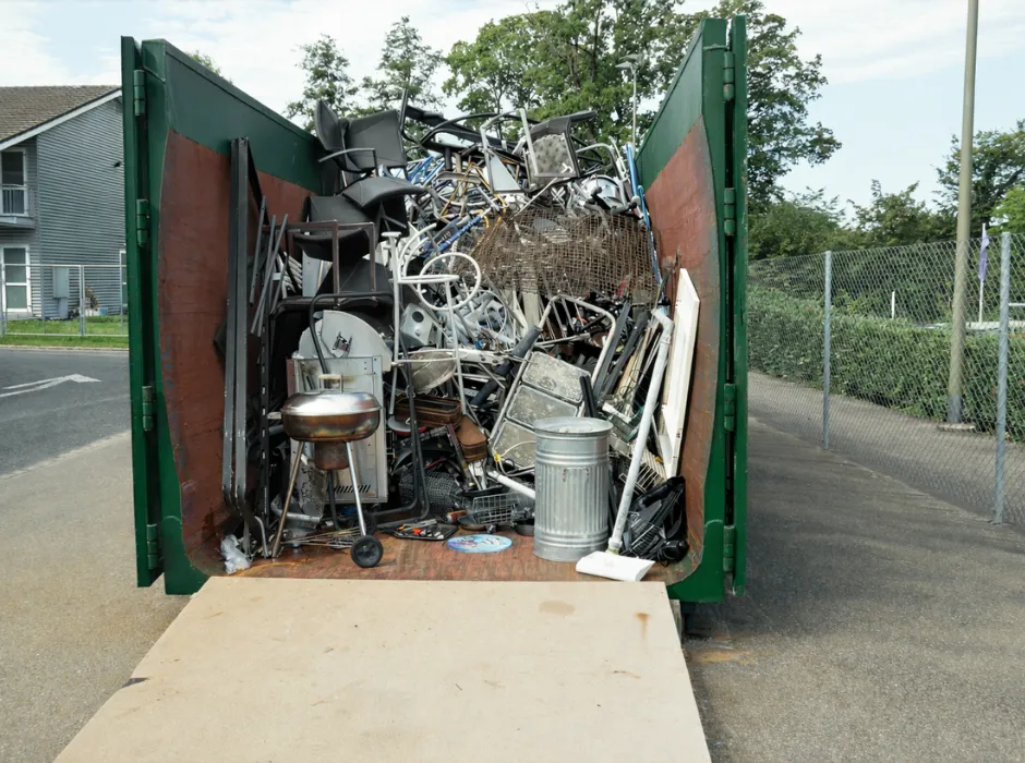 Green dumpster delivered for junk removal service at a residential driveway in Dallas, Texas