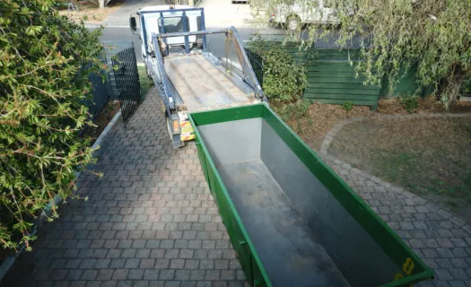 Residential green dumpster filled with household debris during a home cleanout in Dallas, Texas