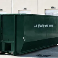 Large commercial dumpster rental positioned at an industrial business site in Dallas