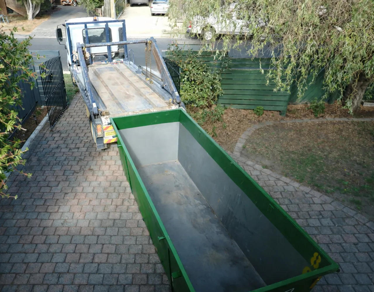 Residential green dumpster filled with household debris during a home cleanout in Dallas, Texas